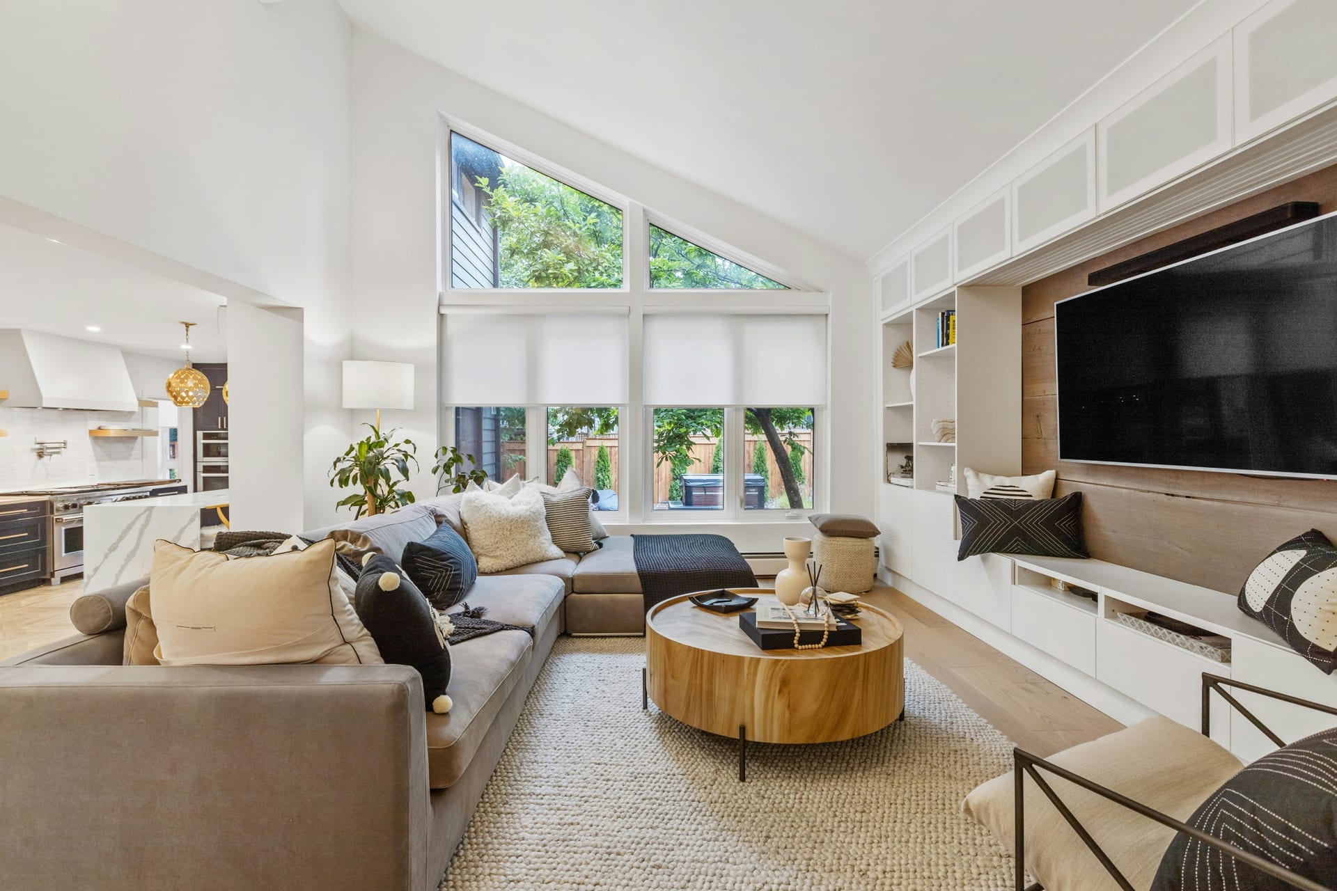 Open-concept kitchen flowing into the living and dining area in a modern Houston home — continuous flooring, large island, and connected sightlines.